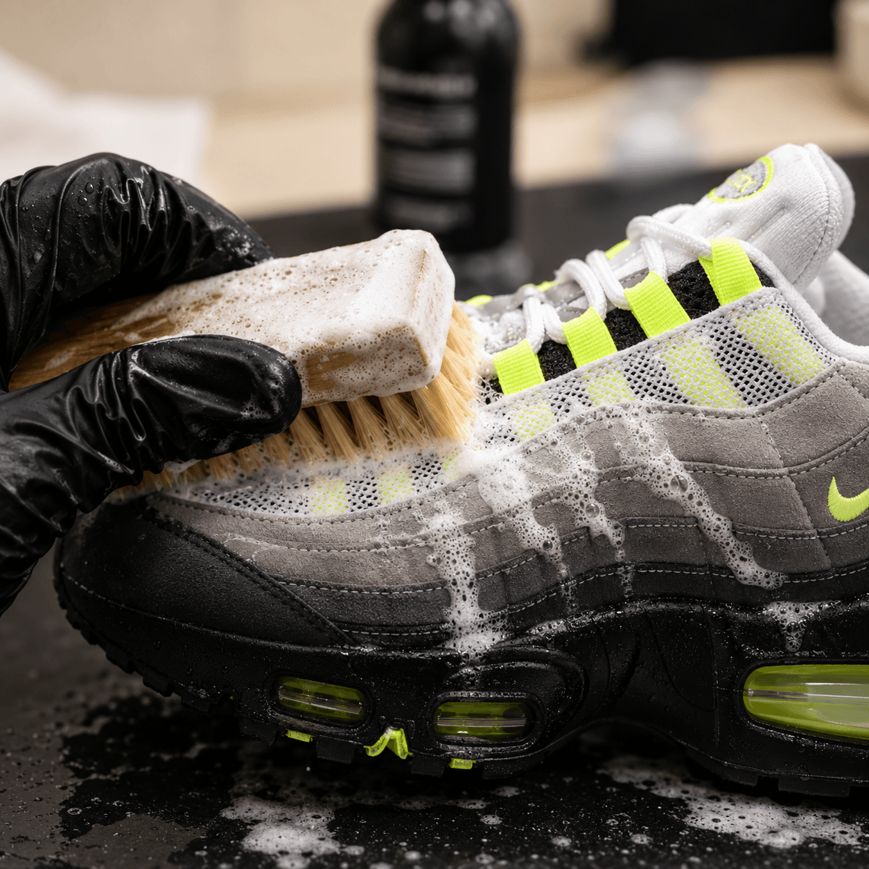 Nettoyage à la brosse d'une Nike Air Max 95, gant noir et mousse