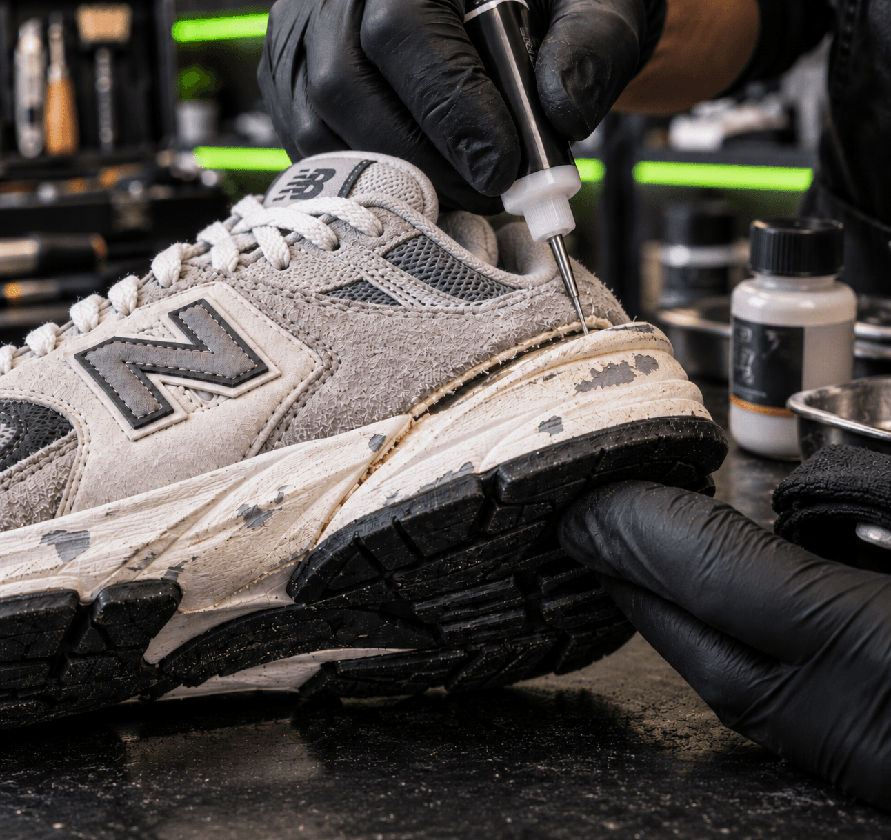 Réparation et restauration minutieuse d'une sneaker New Balance usée, gants noirs