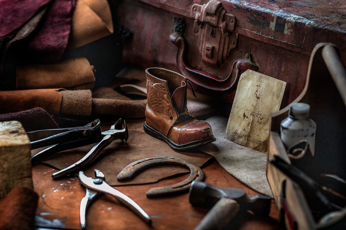 Outils de cordonnier et chaussure en cuir sur un établi d'atelier